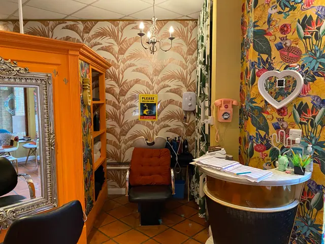 Hair Brighton reception area with bright patterned wallpaper and vintage details